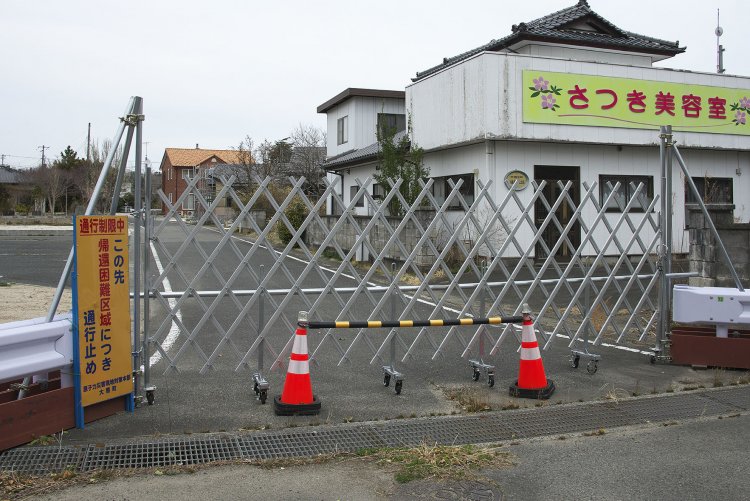 帰還困難区域では家々と道路の間には鉄柵がめぐらされ、入ることができない。