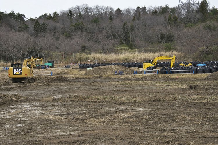 除染作業風景。表土をフレコンバッグに詰めては積み上げる果てしない作業をもう10年も続けている。