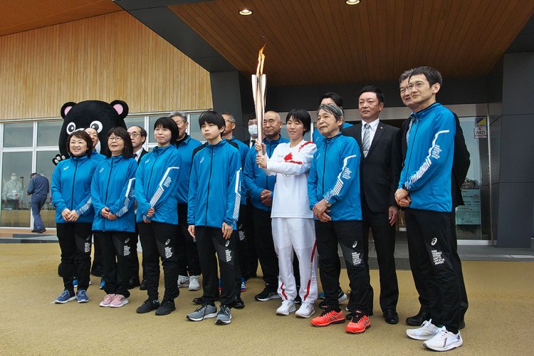 大熊町役場前で走り終えた聖火リレーランナーとサポートランナー