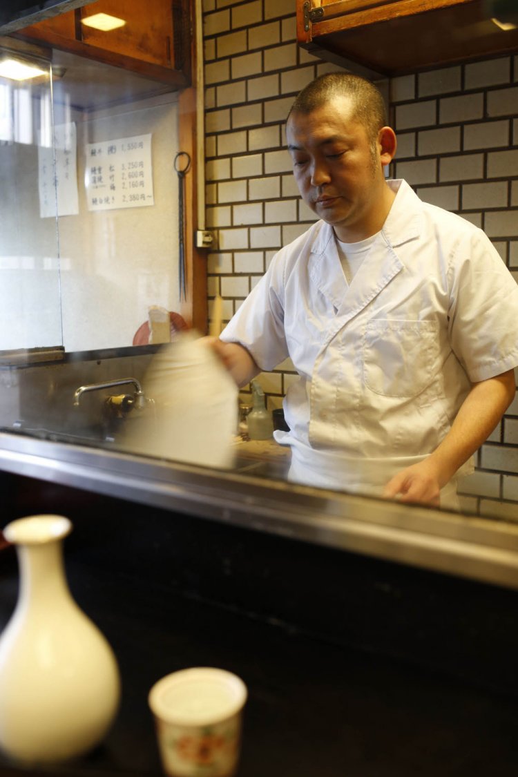 炭火をおこす三代目。