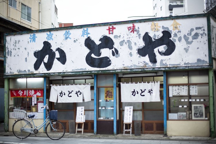 味のある看板と白地暖簾がお出迎え。