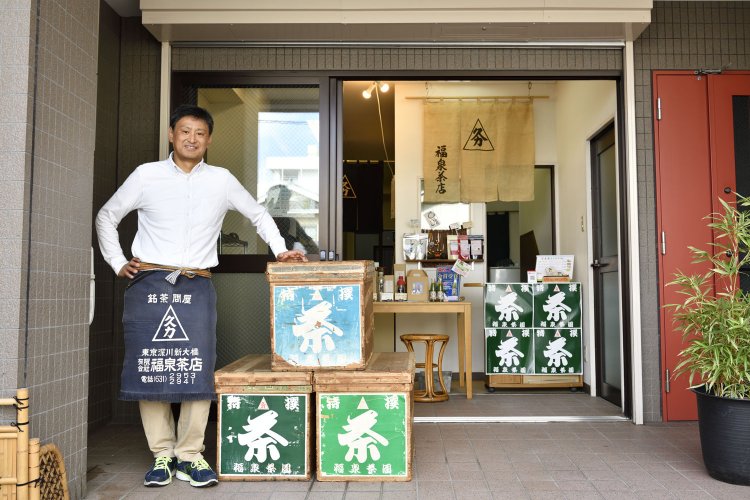 販売している年代物の茶箱と菊地さん。
