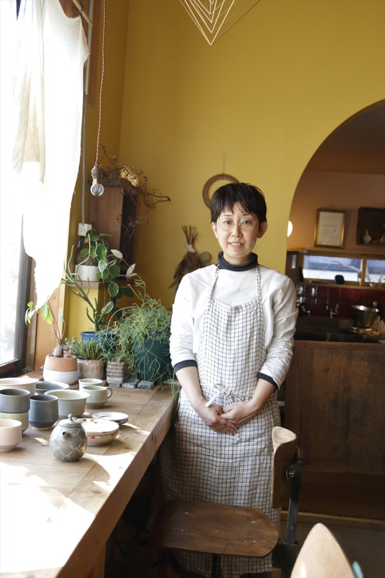 モダンなログハウスのような心地よい店内と水谷さん。