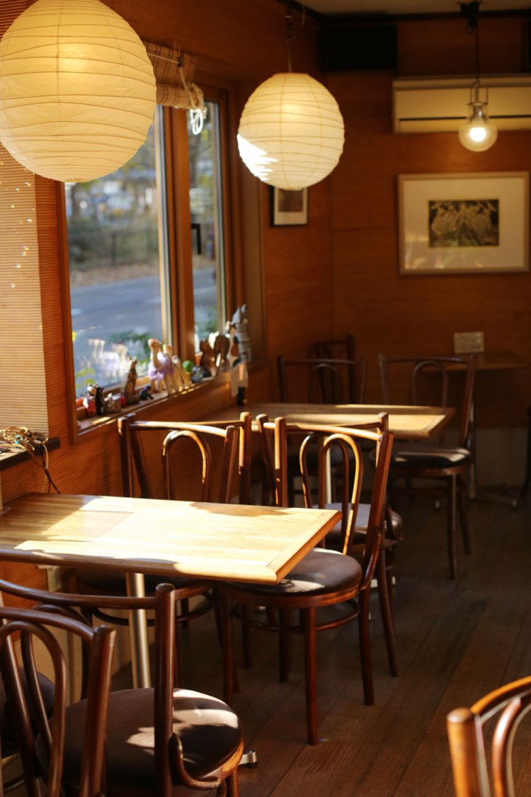 猫の置物がたくさん並ぶ店内。窓の外は、ジブリ美術館へ走る猫バスが。