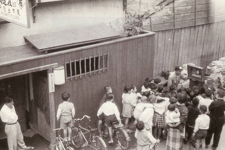 1954年の人形町の紙芝居の様子。おんぶされている柏原さんの姿も。（写真提供＝柏原寛司さん）