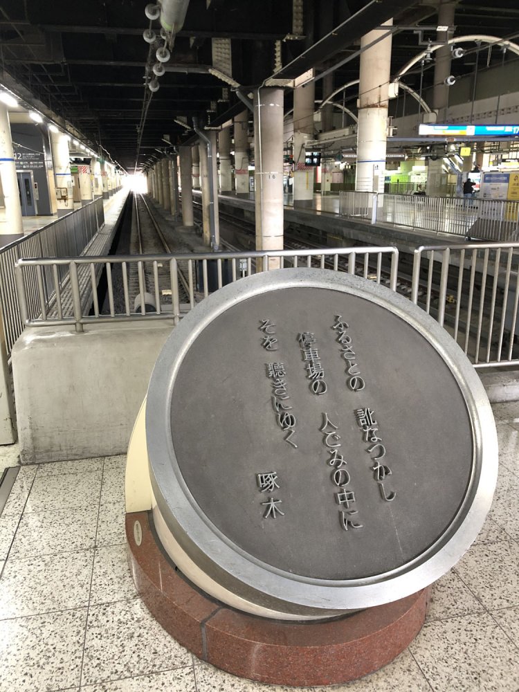 駅構内にある石川啄木の歌碑。この句は明治43年（1910）に出版された歌集『一握りの砂』にも収録されている。