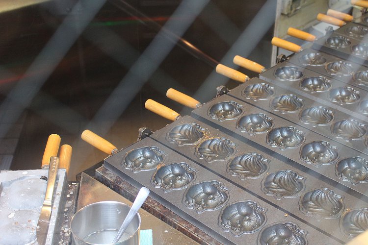 神楽坂通りからガラス越しにペコちゃん焼を焼く様子が見える。