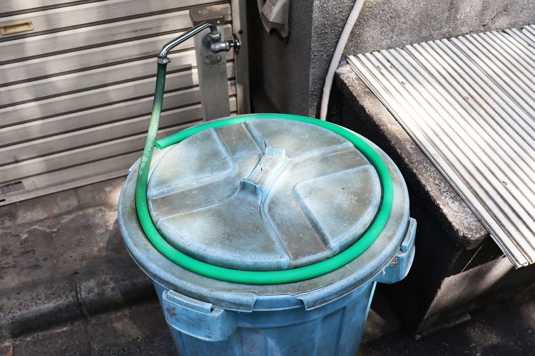 長さがピッタリ！と思わず歓声。ポリバケツの蓋の縁に巻かれたホース。