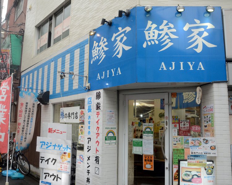 青いテントにデカデカと『鰺家』と記されて外観のインパクトは抜群。数々の名物メニューの写真が展示され、思わず足を止める人も。