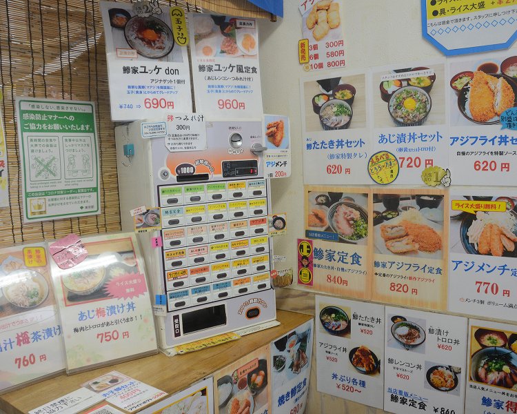メニューは食券でオーダーするシステム。各メニューの写真が飾られているため、定食に加えて単品料理もついつい頼んでしまうというお客さんも多い。