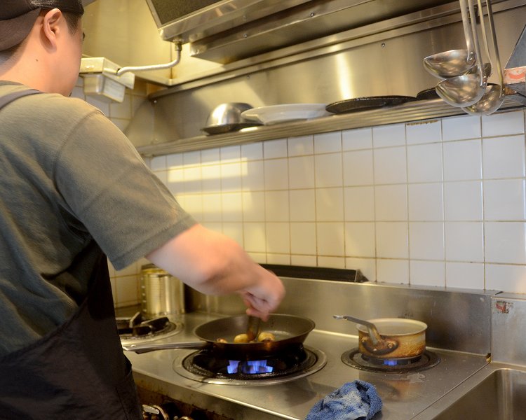 厨房ではオーナーシェフの勉さんが辣腕を振るい調理中。早くもいい匂いが店内を包み込む！