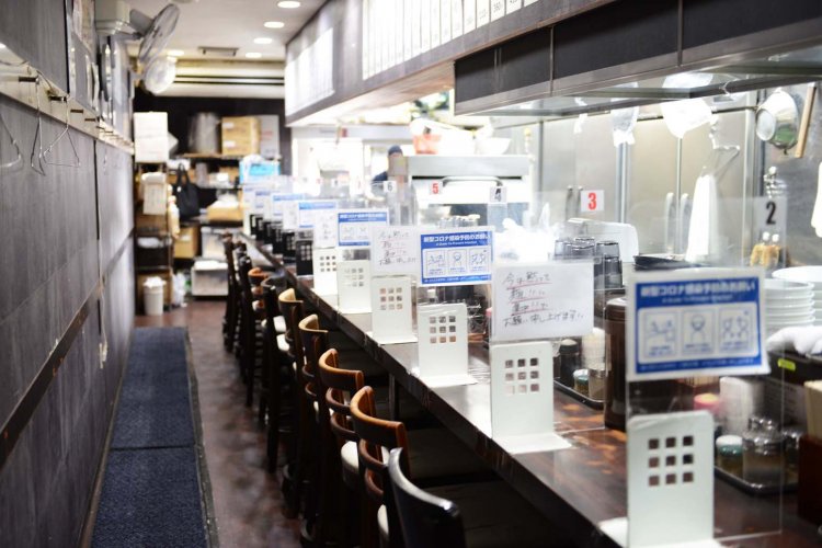 店内はカウンター席が並ぶ店内は長いカウンター席のみ。客が来店すると最奥部の調理場まで注文の声が響く。毎日のように通う常連客もいるという。