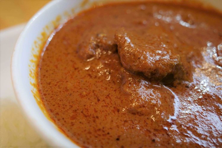 ランチタイムはチキンカレー甘口・辛口、野菜とダル（豆）のカレー、フィッシュカレー、本日のカレーが並ぶ。写真はチキンカレーの辛口1000円。