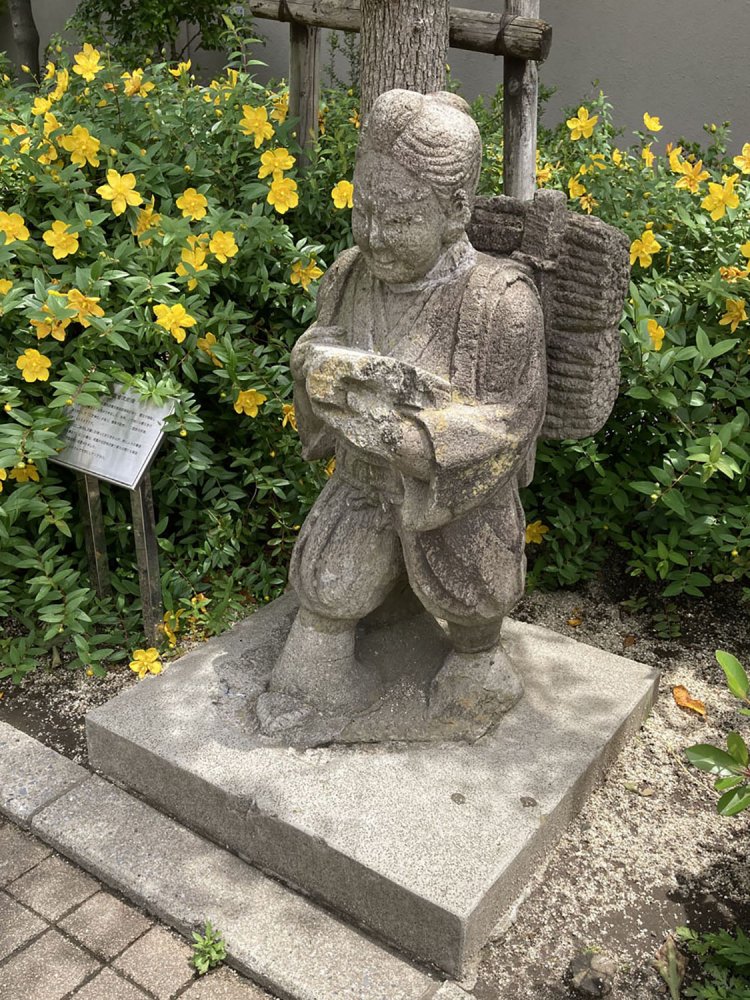 町屋六丁目児童遊園の金次郎。やはり植え込みにひっそりと設置されている（2021年）。