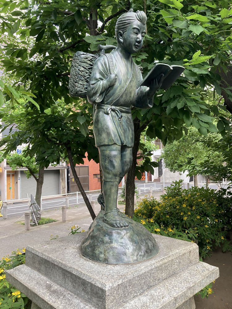 新橋・南桜公園の金次郎。植え込みの目立たないところに佇んでいる（2021年）。