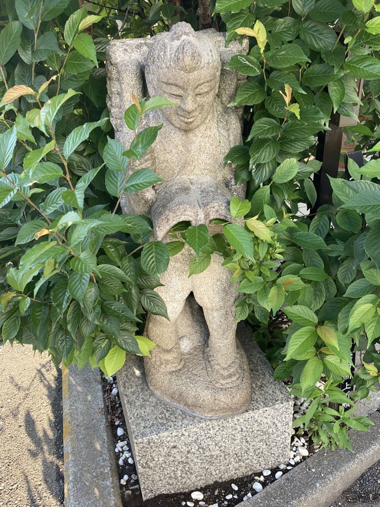 神社自体がビルになっている、中野坂上の八津御嶽神社入り口の金次郎。「二宮金次郎さんの頭を一回なでて学力向上」という札が立っている（2021年）。