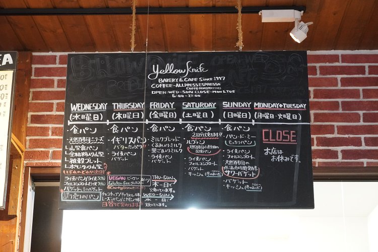 黒板にパンの品揃えの日程がずらり。サンドイッチなどもあるので、店頭に並ぶ種類はもっと多い。