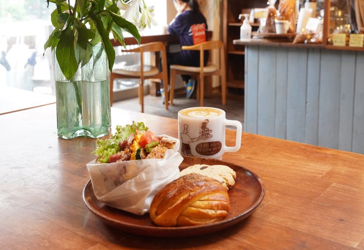 ゆったりとしたイートインスペース。サンドイッチ410円、カルダモンロール291円、カントリービスケット216円とカフェラテ518円。