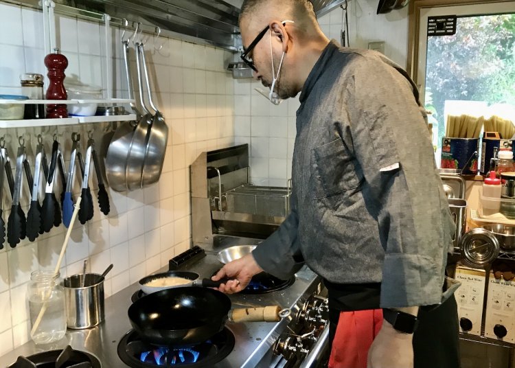 エビとトマトのクリームソースを火にかける高田さん。その堂々たる身のこなしは、どこからどう見ても生粋のシェフに見えるのだが……。