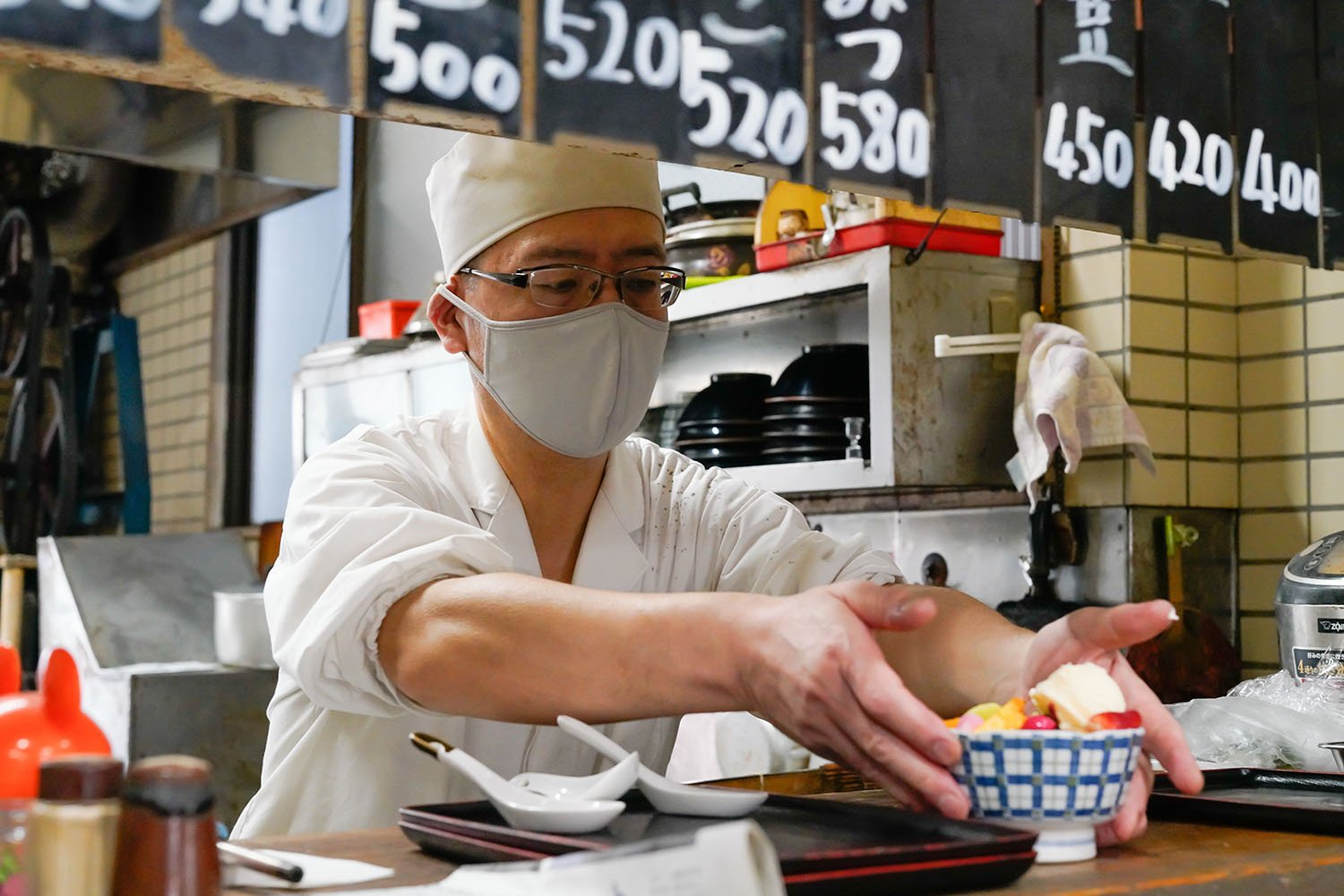 ほい、こちらが本業。と、人気のクリームあんみつを差し出す店主の石山繁さん。