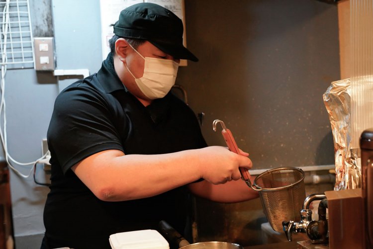 言葉少なに、濃厚な鶏そばを仕上げる浅野さん。