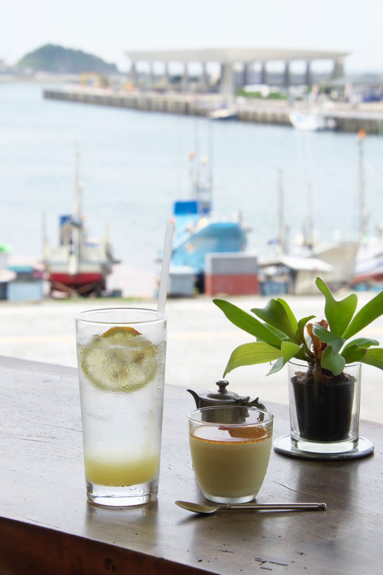 2階の窓から望む港風景。左手前は定番の飲物・オーガニック・レモンソーダ500円。右は人気の雀家プリン350円。