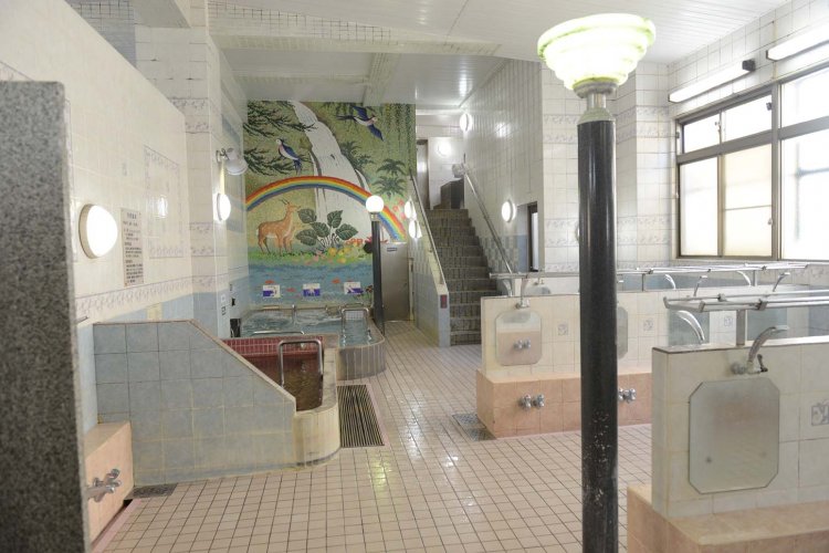 鹿の親子が印象的な女性用大浴場。男性用大浴場はシンメトリーの配置。