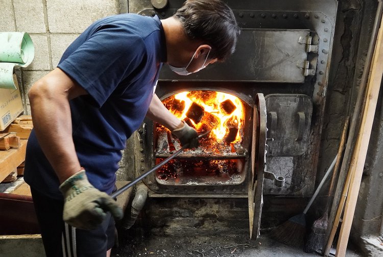 薪を焚き続ける、3代目店主の坂下三浩さん。