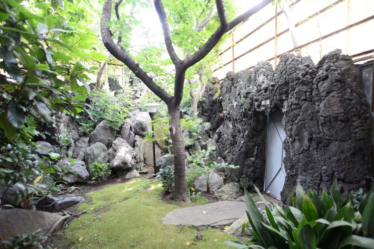 男湯の坪庭。岩、木々、苔などが巧みに配置されている。