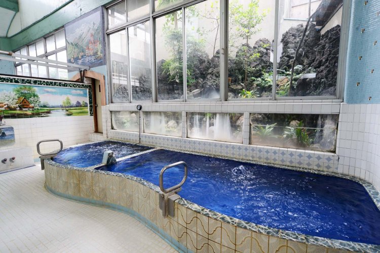 内側に紺色のタイルを貼った浴槽。窓を開ければ風が感じられ、半露天風呂の気分。 