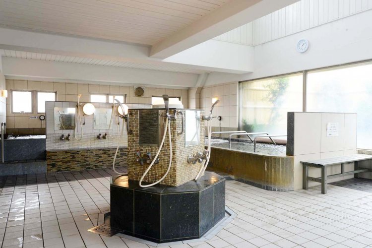 大きな窓から陽が差し込む3階浴室。中央部にカランを配した珍しい造りだ。