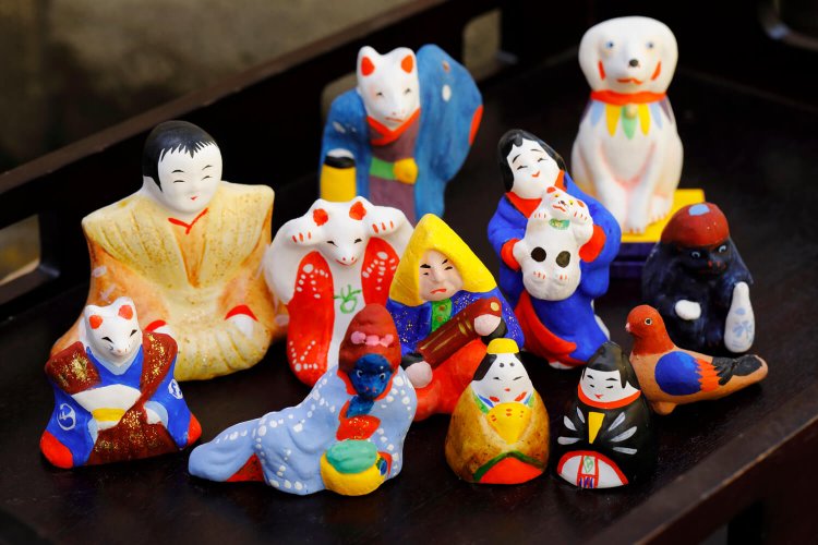 手前から、一文雛、娘河童、丸〆狐、 裃雛、狐拳、提灯狐、ぴいぴい（犬）など。 モチーフは豊富だが、猫や狐が多い。中に玉が入りカラカラ鳴る物が多いのも特徴。価格の目安は1体3000円前後。