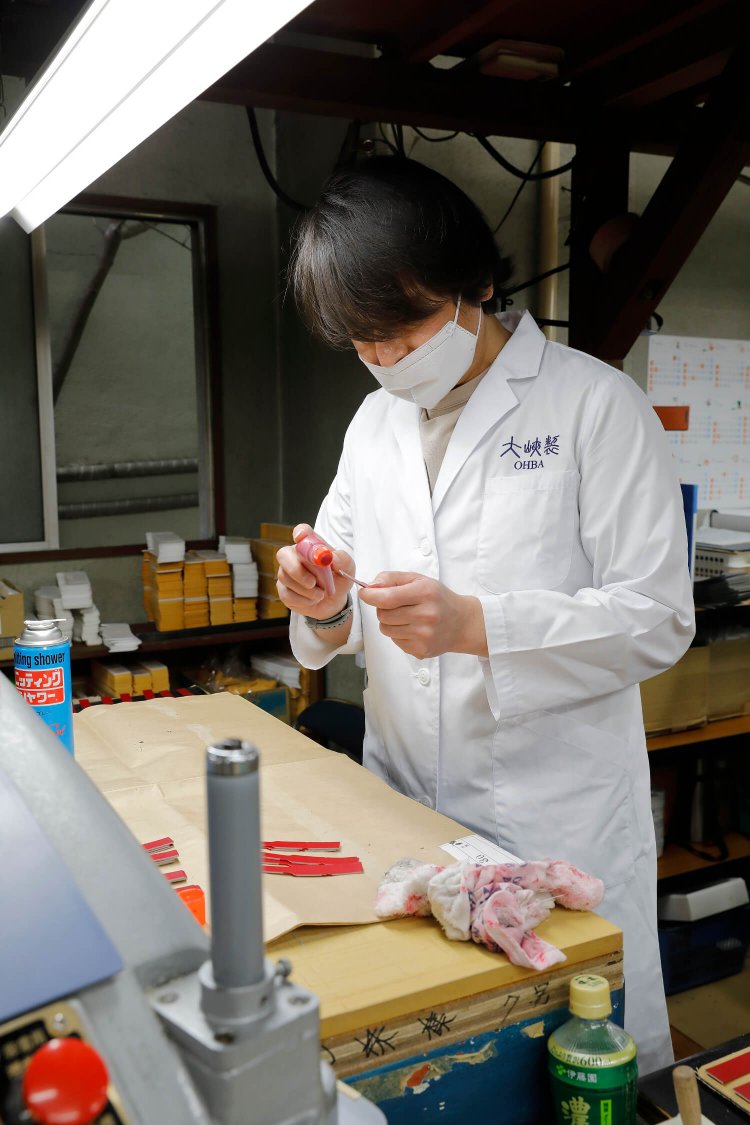 パーツの断面にニスを塗り重ねる「コバ塗り」の作業。