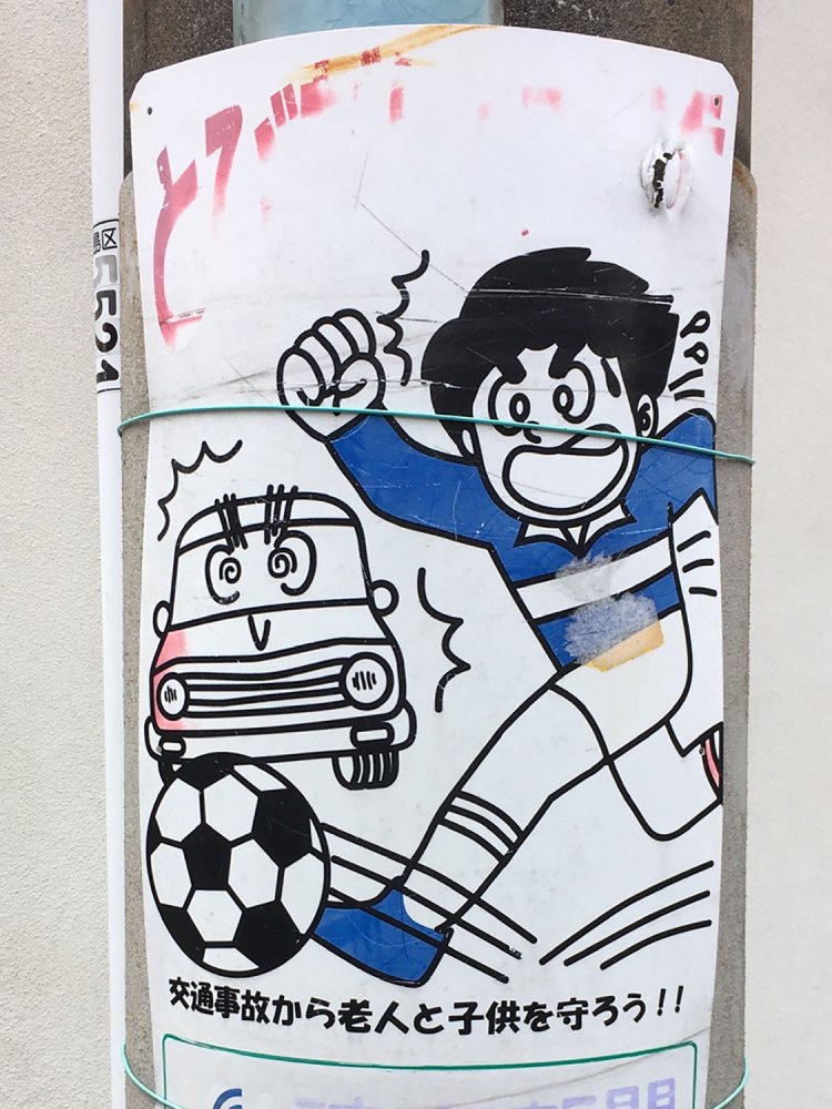 少年マンガ風の絵柄。車が擬人化される場合、フロントグリルが口になりがち（目白・2020）