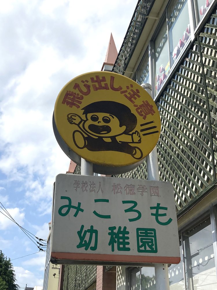幼稚園入り口に設置された看板。幼児がトコトコ走ってくるイメージ（高尾・2021）