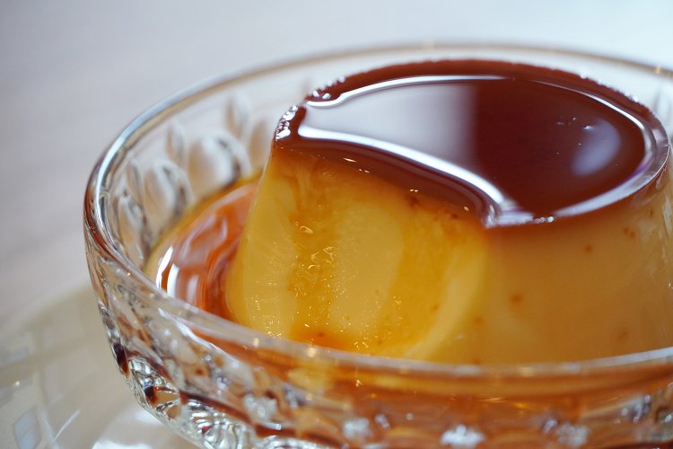 粘度の低いカラメルソースがプリンに流れ落ちる。