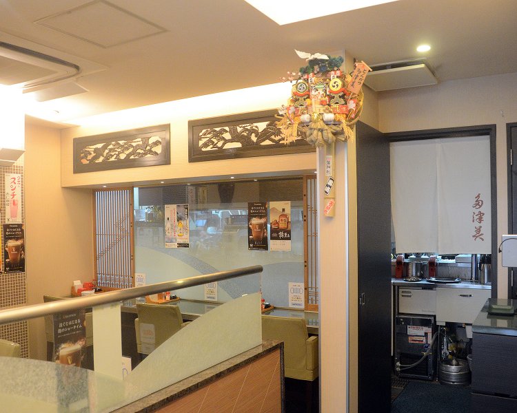 店内はテーブル席のほか、カウンター席も備える。真ん中に飾られる熊手がどこか懐かしい雰囲気に。