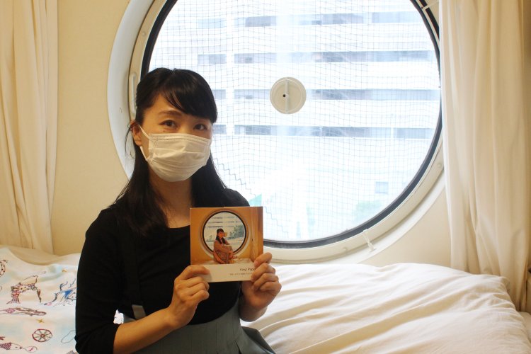 手にしているのはカプセルで撮影した自作のZINE。密かに人気で重版中。