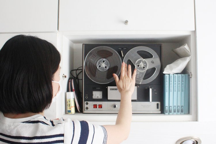 自分の家から持ってきたオープンリールのテープをセットするおかもとさん。