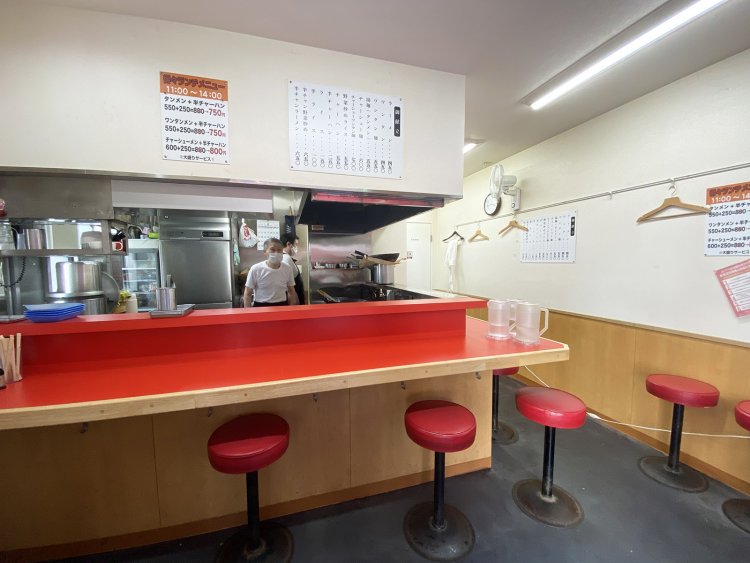 カウンター9席のみの小さな店。ホールを担当するおかみさんが人情味あふれる笑顔で迎えてくれたが、写真を撮らせてとたのむと逃げてしまった。