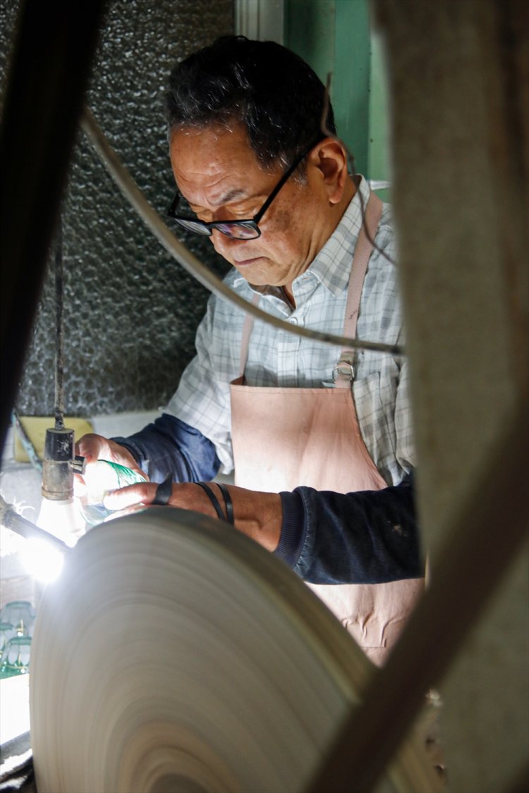 グラスを砥石がけする父・康夫さん。長年の勘で見事に平らにしていく。