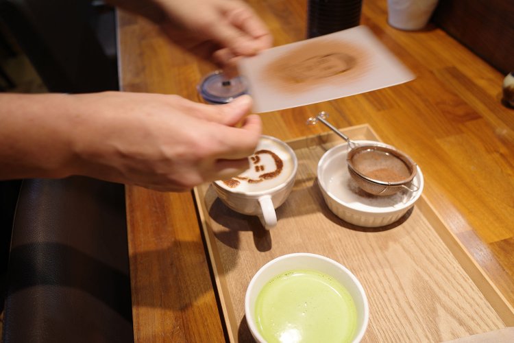 ココアパウダーで栄一の肖像を描く。