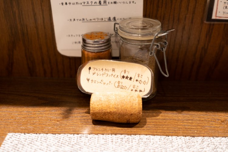 フレンチカレーに辛さやスパイス感を足したいひと向けに、カウンターにはスパイスの小瓶が置かれている。