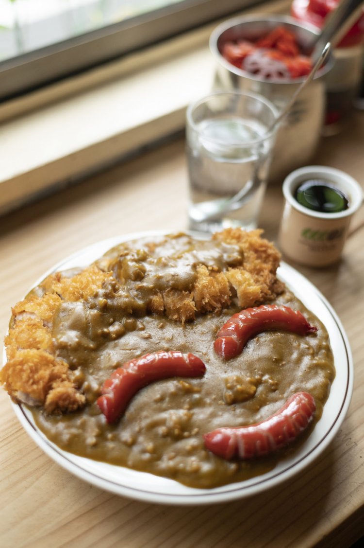 カツウインナーカレー1200円に、店主が多忙でないときはウインナーをスマイル型にしてくれる。ミニコーヒーは無料サービス。