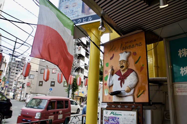 『メランツアーネ』店舗入口。イタリアンシェフの看板に歴史を感じる。