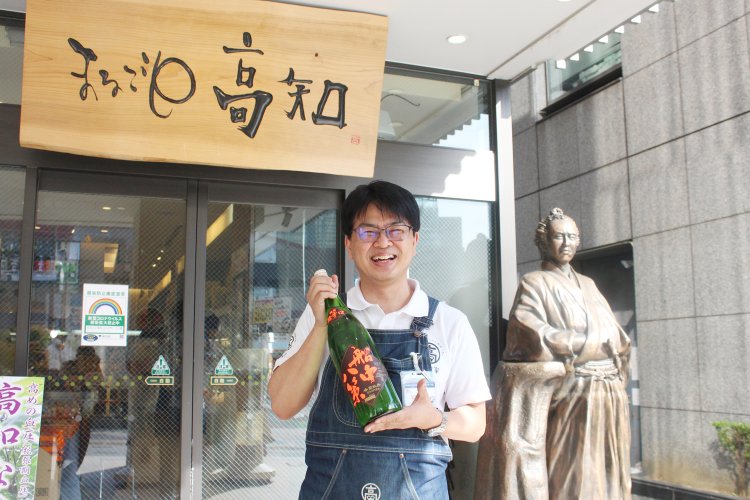 夏の日の光を浴びてアツアツになった龍馬像とともに迎えてくれる藤原さん