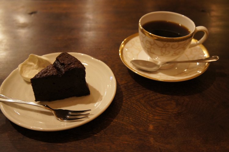 ショコラケーキ650円は優しい味わい。ウェッジウッドのカップソーサーがテーブルに映える。