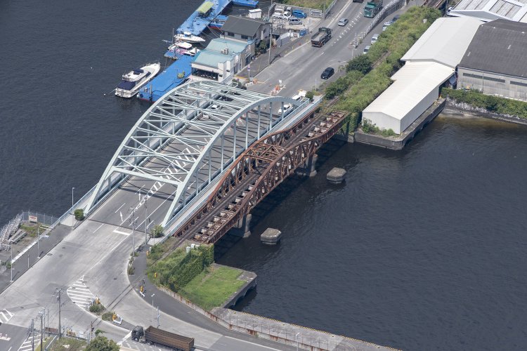 南側の米軍基地側から見た瑞穂橋。両端がプレートガーダー、中心部が曲弦トラスの複線という構造がよくわかる。線路は単線分のみ。橋脚はプレートガーダーとトラスの接合部ではなく、トラス側で支えている。