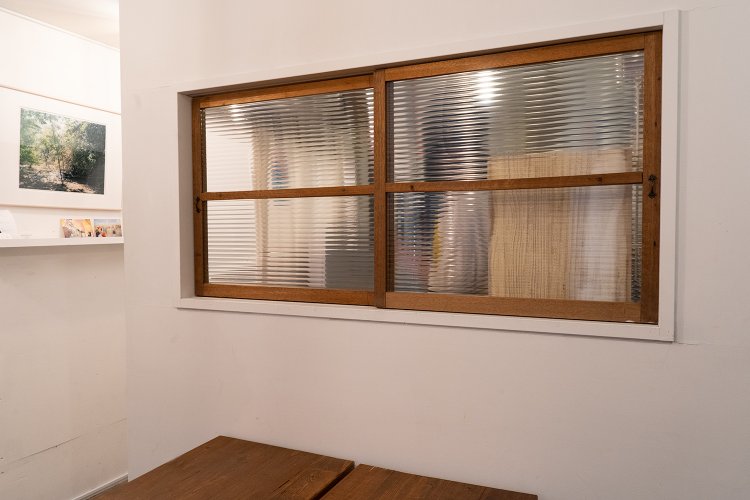 懐かしい波ガラスの窓の向こうにキッチンがある。