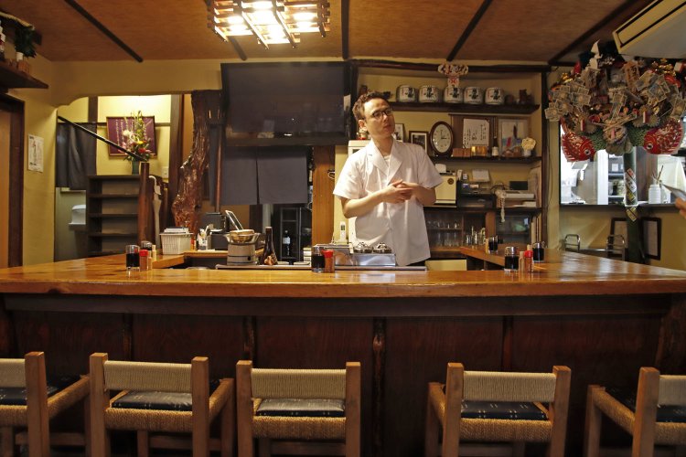 カシワの木柱、コの字の木製カウンターなど、3代目が大切に守り継ぐ。